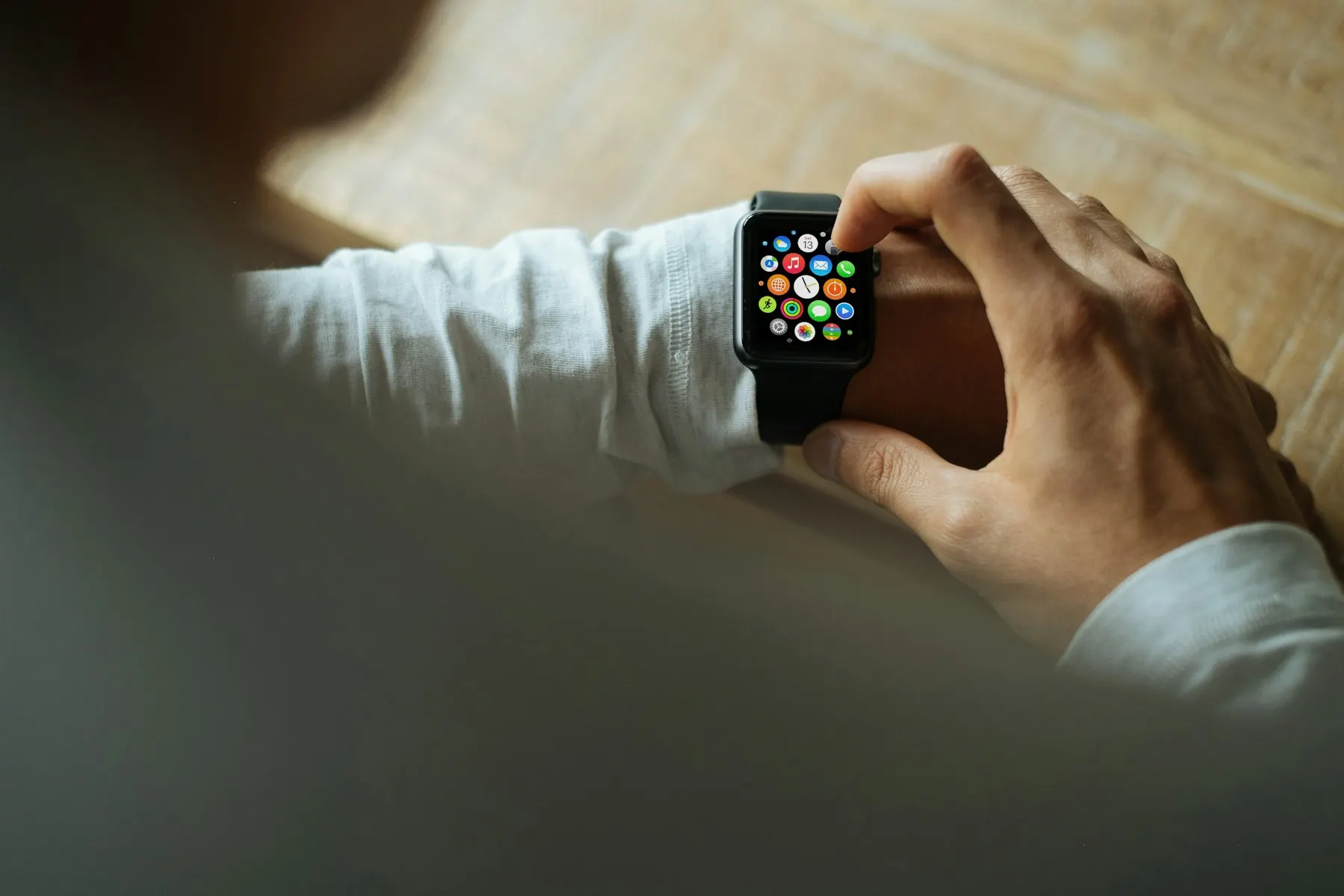 Une personne touche une montre connectée à son poignet